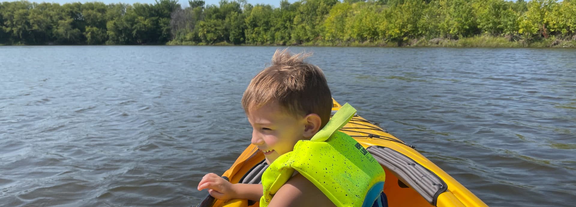 Child in kayak looking at water