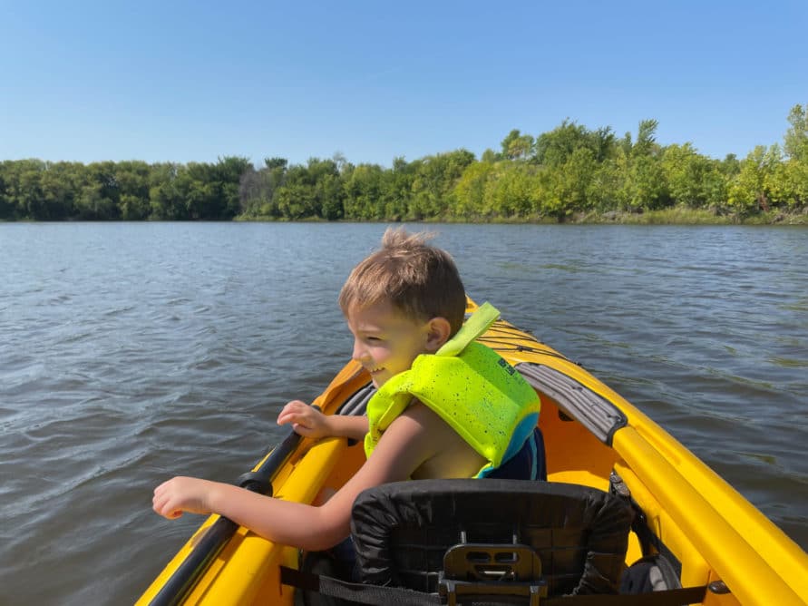Child in kayak looking at water